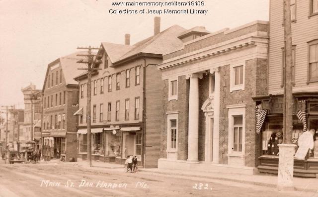 Black-and-white photograph of Main Street in Bar Harbor around 1916, showing a tall columned building among other storefronts.